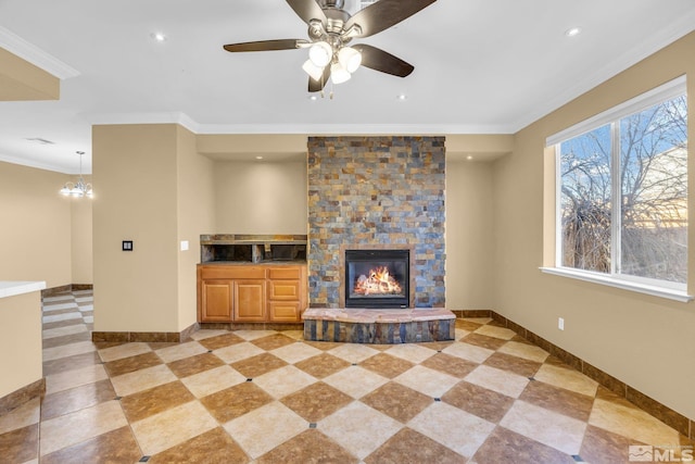 unfurnished living room featuring ceiling fan with notable chandelier, a fireplace, and ornamental molding