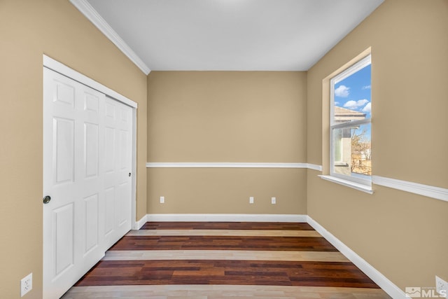 unfurnished bedroom with dark hardwood / wood-style floors and a closet