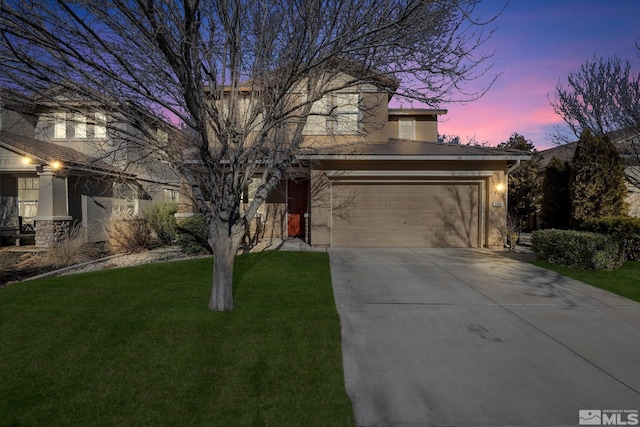 view of front of house featuring a garage and a yard