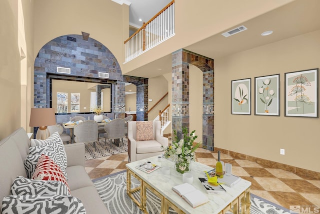 living room featuring decorative columns and a high ceiling