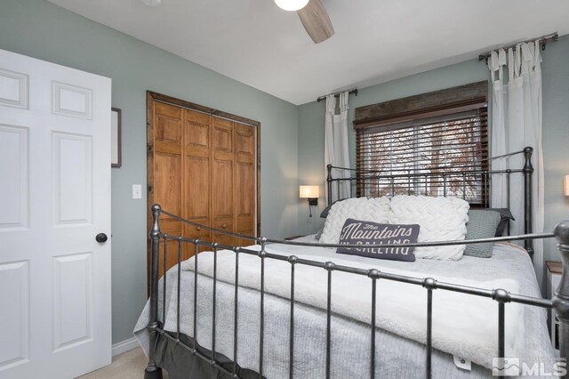 carpeted bedroom featuring ceiling fan and a closet