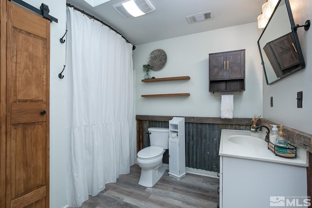 bathroom with hardwood / wood-style flooring, vanity, and toilet