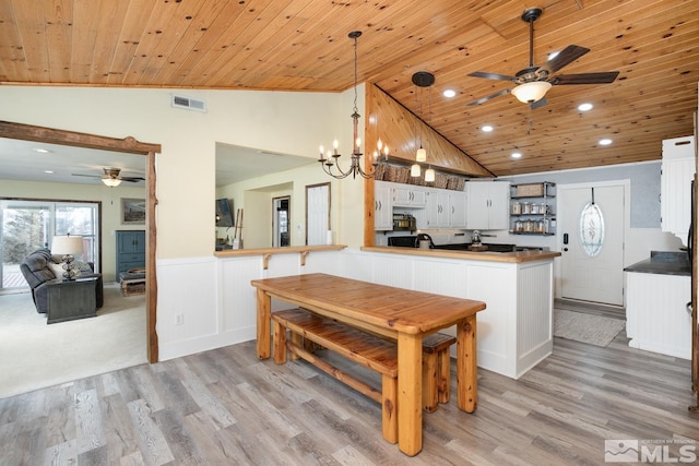 kitchen with pendant lighting, wood ceiling, light hardwood / wood-style floors, white cabinets, and kitchen peninsula