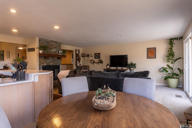 carpeted dining area featuring a fireplace