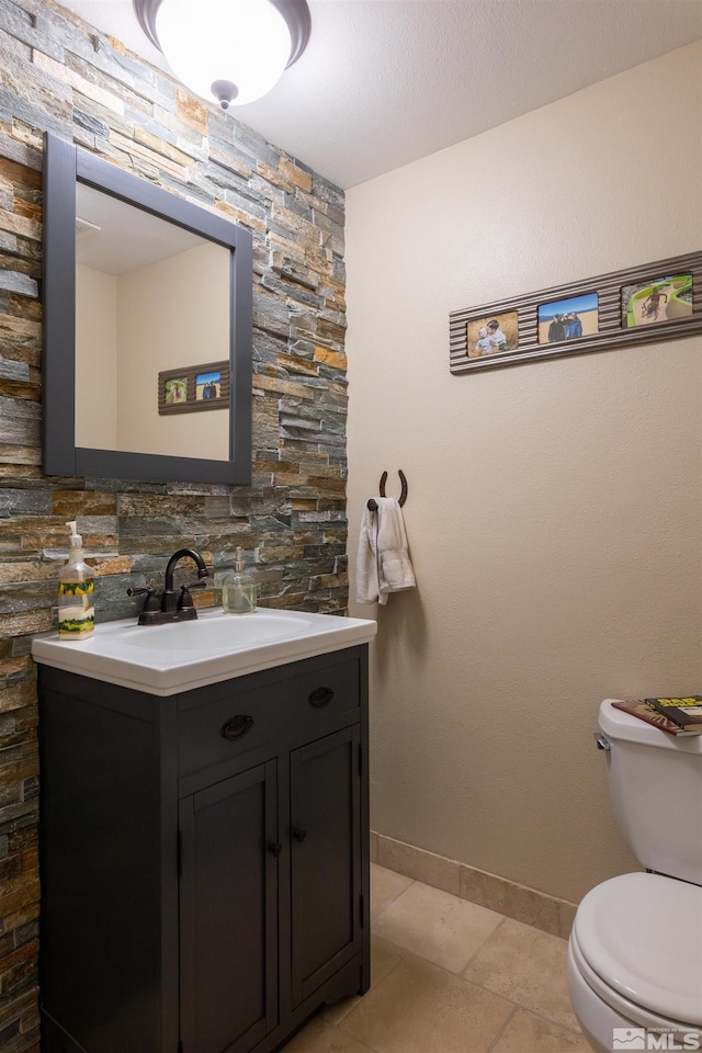 bathroom featuring vanity, tile patterned flooring, and toilet