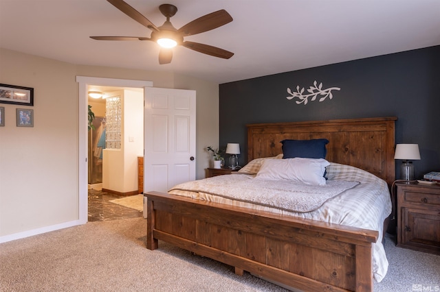 bedroom featuring ceiling fan, light colored carpet, and connected bathroom