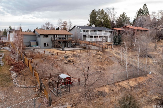 back of house with a wooden deck and a jacuzzi