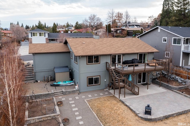 rear view of property with a wooden deck, an outdoor fire pit, a hot tub, and a patio