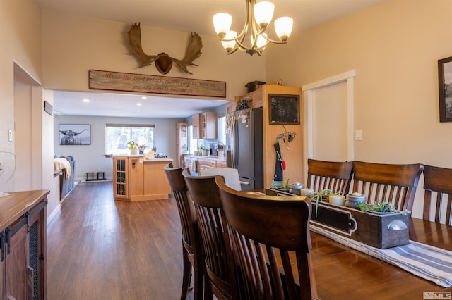 dining space featuring dark wood-type flooring and a chandelier