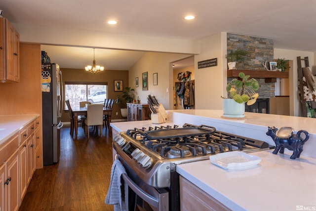 kitchen with pendant lighting, dark wood-type flooring, an inviting chandelier, stainless steel appliances, and vaulted ceiling