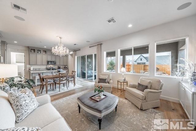 living room featuring an inviting chandelier and light hardwood / wood-style flooring