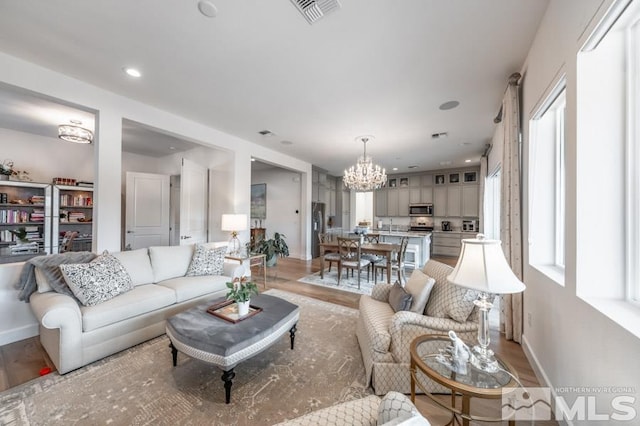 living room featuring light hardwood / wood-style flooring and a chandelier