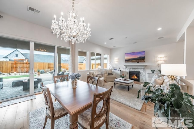 dining room featuring a fireplace and light hardwood / wood-style flooring