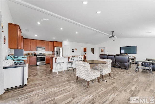 dining space with lofted ceiling and light hardwood / wood-style floors