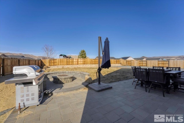 view of patio with area for grilling and a fire pit