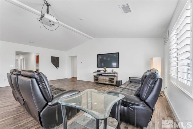 living room with hardwood / wood-style flooring and vaulted ceiling with beams