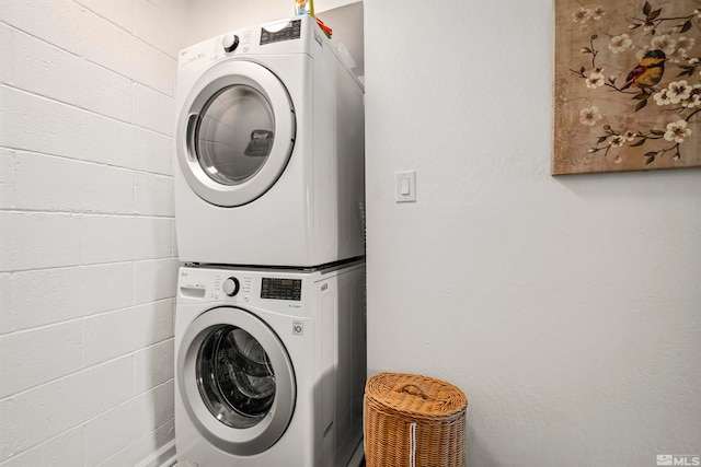 clothes washing area with stacked washer / dryer