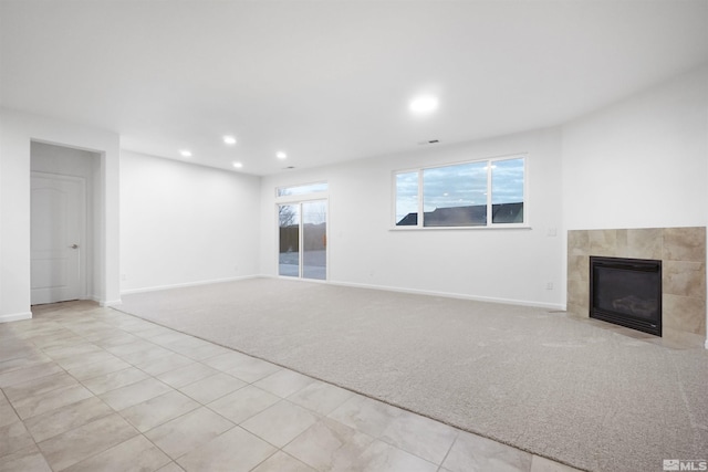 unfurnished living room featuring light colored carpet and a tile fireplace