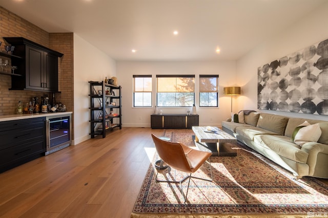 living room with wine cooler, indoor bar, and light hardwood / wood-style flooring