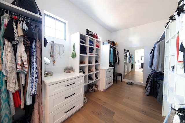 walk in closet with light hardwood / wood-style floors