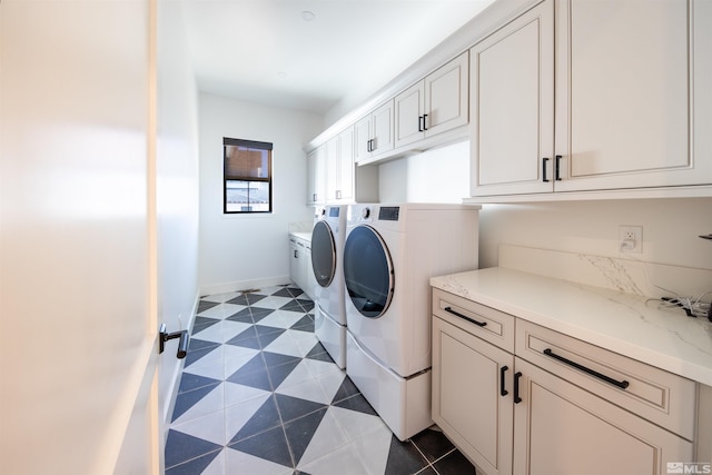 clothes washing area featuring cabinets and washing machine and dryer