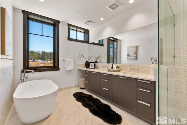 bathroom featuring vanity and a tub to relax in