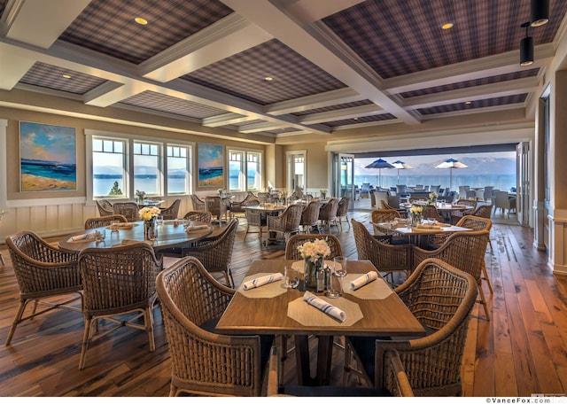 dining area with crown molding, beam ceiling, dark hardwood / wood-style floors, a water view, and coffered ceiling