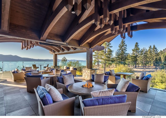 view of patio / terrace featuring an outdoor living space with a fire pit, a water and mountain view, and a gazebo