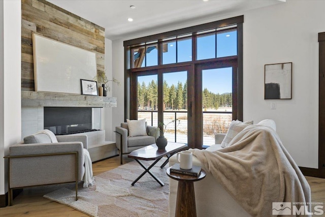 interior space with a large fireplace, hardwood / wood-style floors, and wood walls