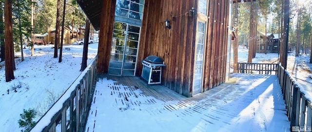 snow covered deck with a grill