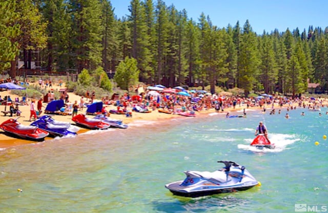 view of property's community with a beach view and a water view