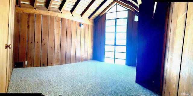 carpeted spare room with vaulted ceiling with beams, wood ceiling, and wooden walls