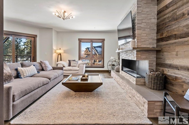 living room featuring hardwood / wood-style flooring, a fireplace, and wood walls