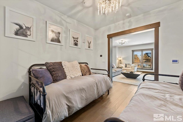 bedroom with a notable chandelier and light hardwood / wood-style flooring