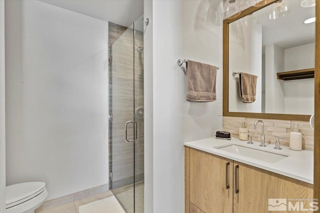 bathroom with a shower with door, vanity, backsplash, and toilet