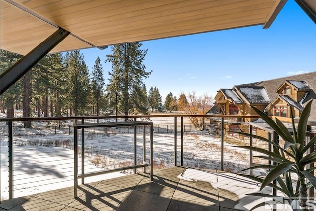 view of snow covered back of property