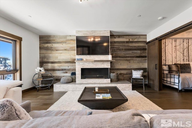 living room with hardwood / wood-style flooring, a fireplace, and wood walls