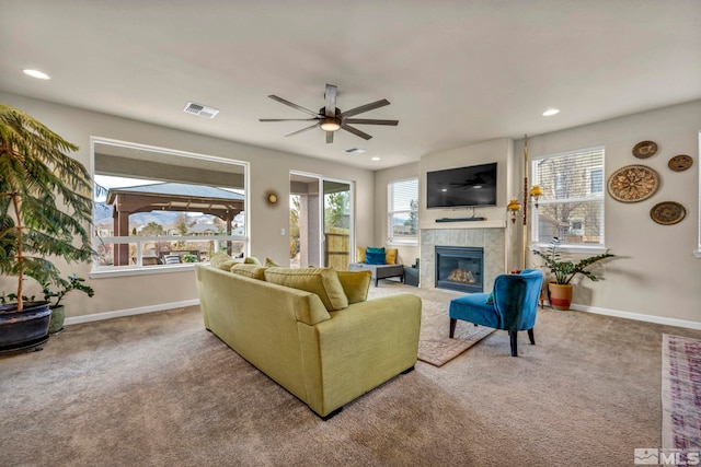 living room featuring ceiling fan, carpet floors, and a fireplace