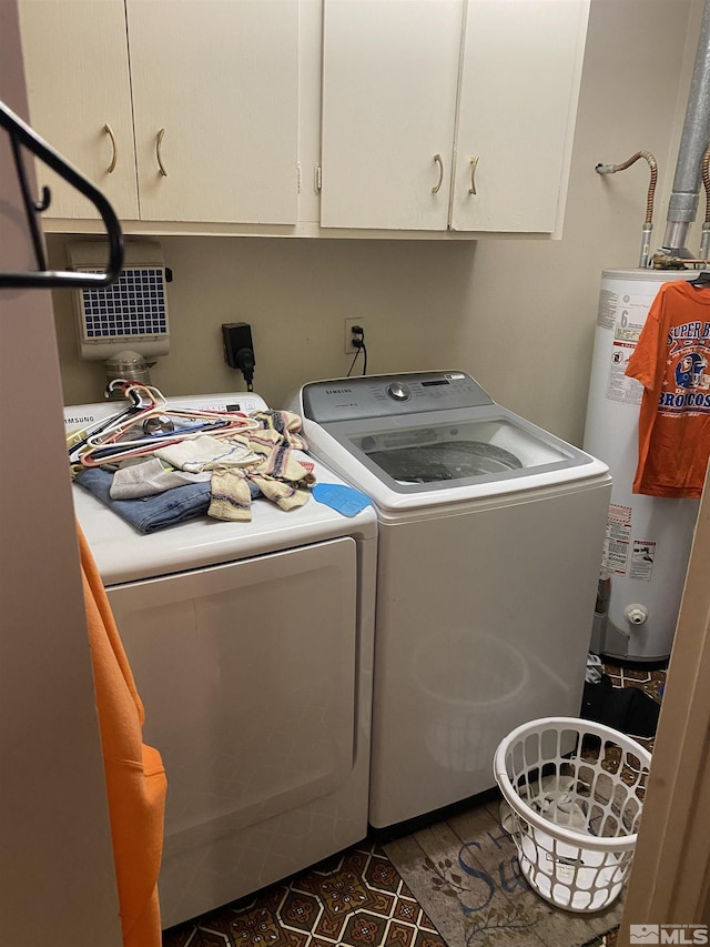 laundry room with water heater, cabinets, and washer and clothes dryer