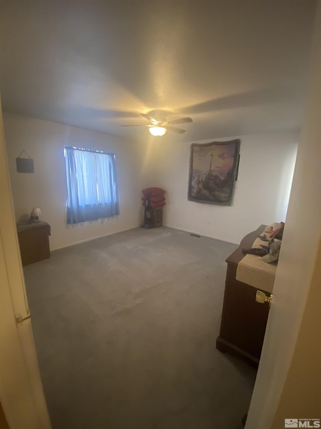 interior space featuring ceiling fan and carpet