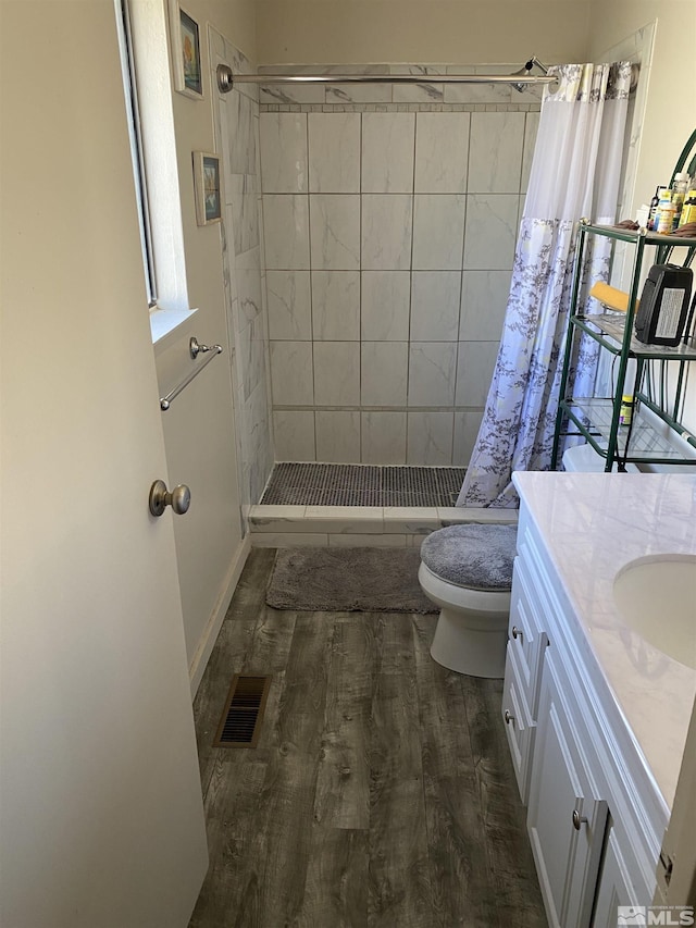 bathroom with vanity, curtained shower, wood-type flooring, and toilet