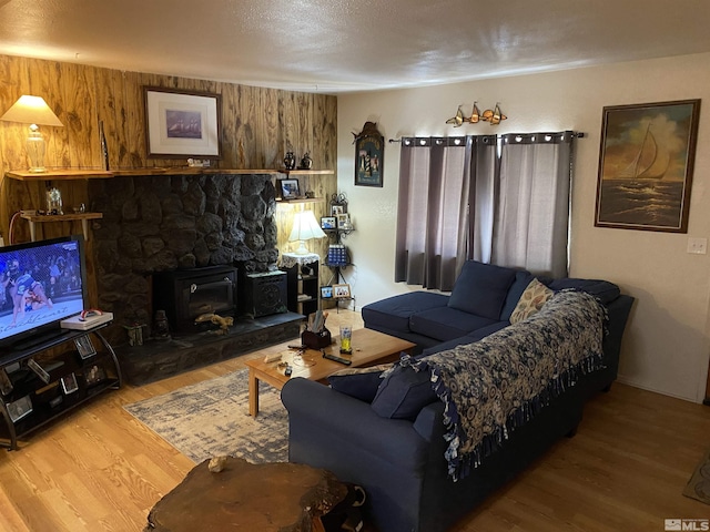 living room featuring a stone fireplace and hardwood / wood-style floors