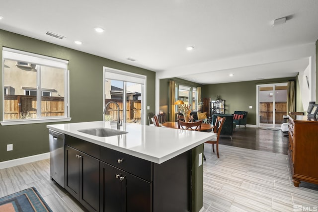 kitchen featuring an island with sink, dishwasher, and sink