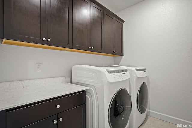 washroom with cabinets and washing machine and clothes dryer