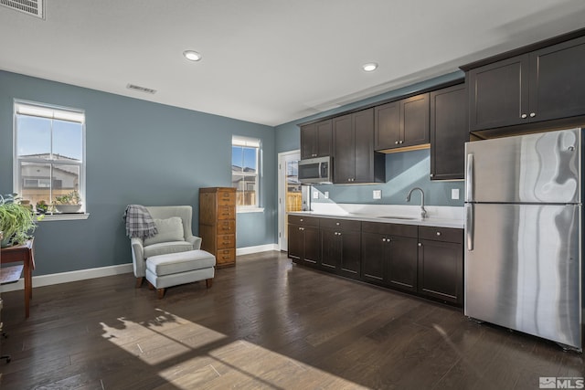 kitchen featuring stainless steel appliances, dark hardwood / wood-style floors, sink, and dark brown cabinets