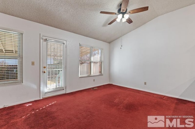 carpeted empty room featuring ceiling fan, lofted ceiling, and a textured ceiling