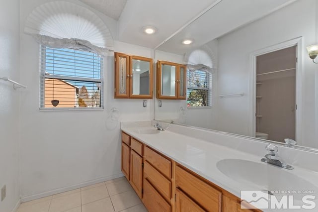 bathroom featuring tile patterned flooring, vanity, plenty of natural light, and toilet