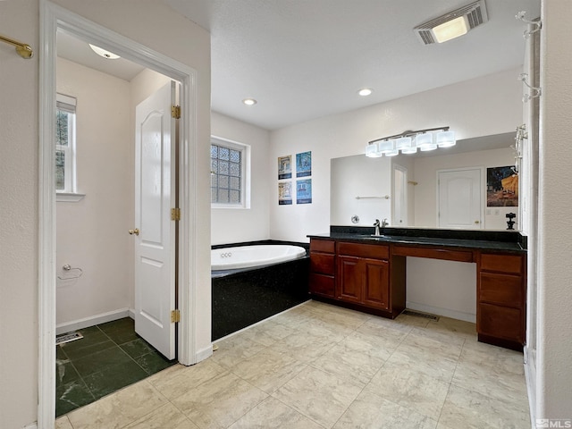 bathroom with vanity and a bath