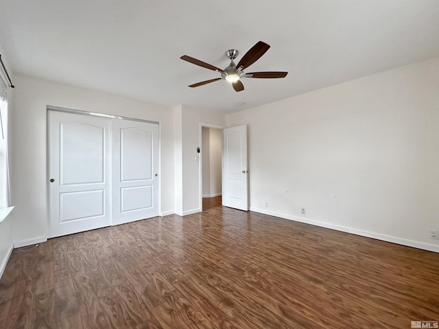 unfurnished bedroom with dark hardwood / wood-style flooring, a closet, and ceiling fan