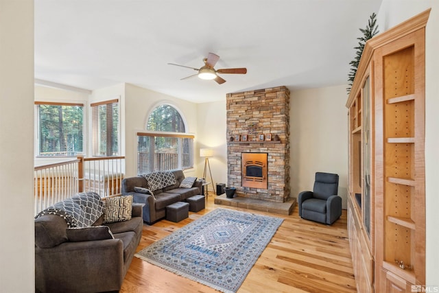 living room featuring a fireplace, hardwood / wood-style flooring, vaulted ceiling, and ceiling fan